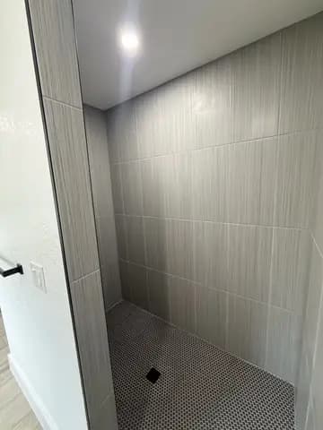 Marble-look tiled shower in a completed bathroom remodel