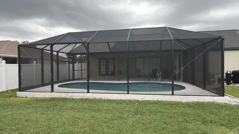 Pool cage and screen enclosure over a backyard pool