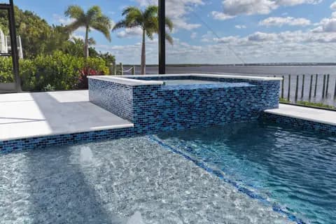 Custom pool with infinity edge and travertine deck