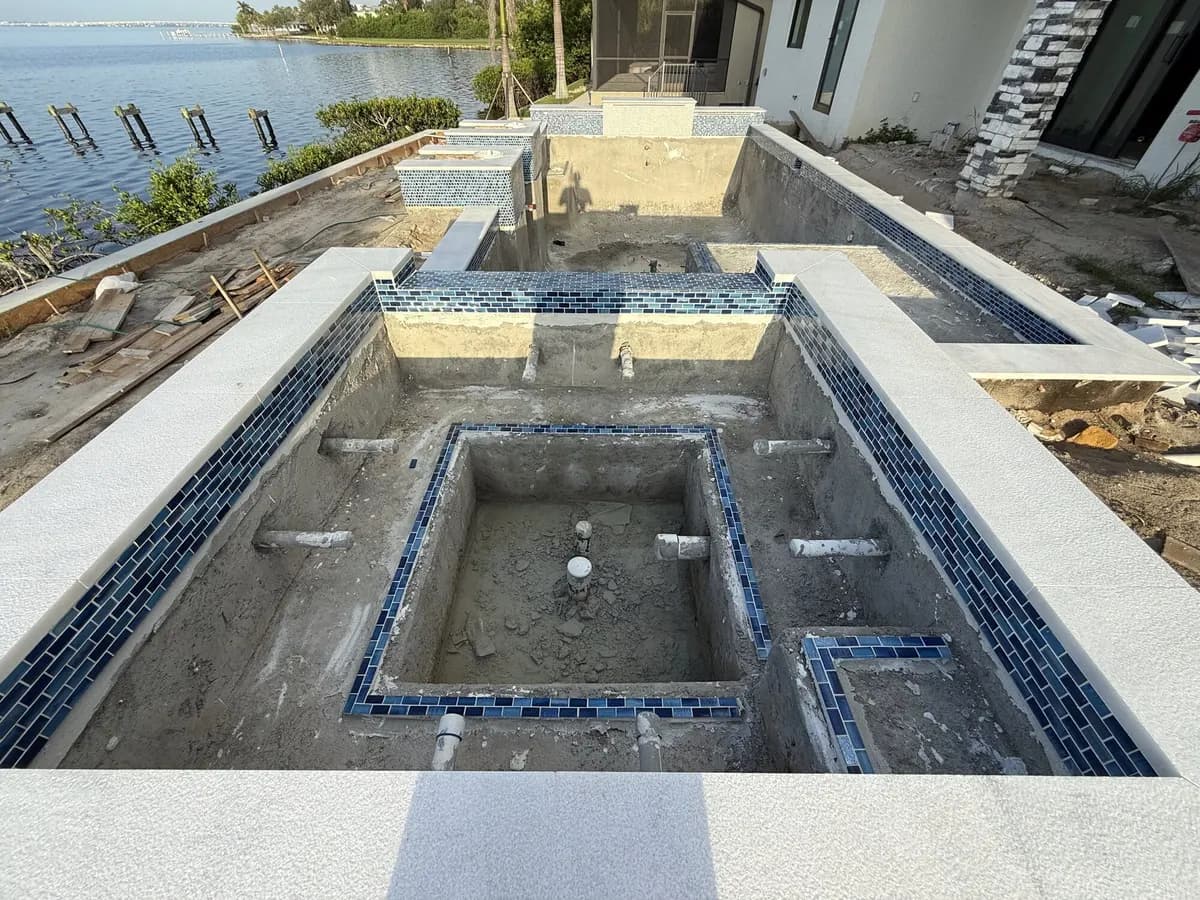 Blue mosaic tile and coping installation on spa